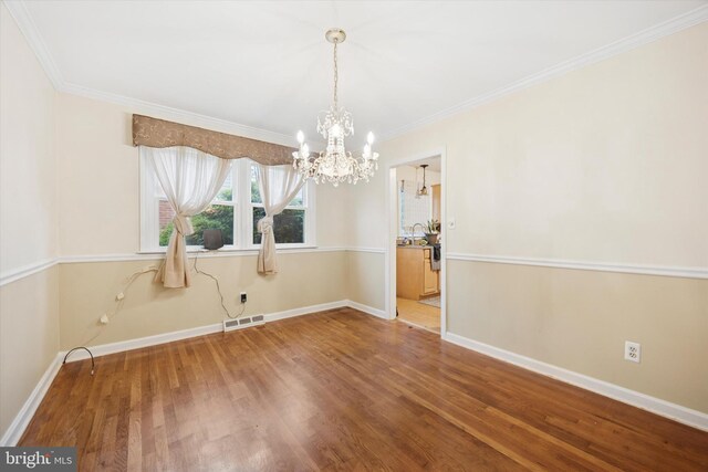2722 E Riding Dr, Wilmington, DE 19808 - unfurnished dining area with a chandelier, wood finished floors, crown molding, and baseboards