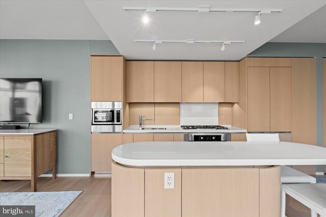 925 H St NW Unit 810, Washington, DC 20001 - kitchen with track lighting, light brown cabinetry, stainless steel microwave, a kitchen island, and light wood finished floors
