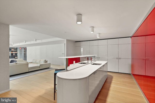 925 H St NW Unit 810, Washington, DC 20001 - kitchen featuring a sink, light wood-style flooring, a center island with sink, and modern cabinets