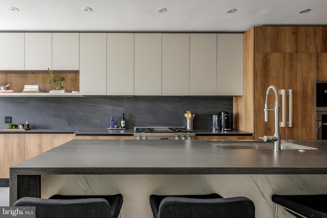 1914 35th St NW, Washington, DC 20007 - kitchen with dark countertops, modern cabinets, stove, a kitchen bar, and recessed lighting