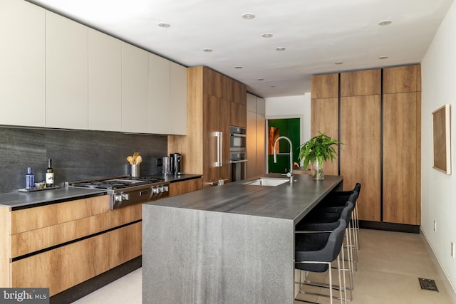 1914 35th St NW, Washington, DC 20007 - kitchen with modern cabinets, stainless steel gas stovetop, dark countertops, backsplash, and an island with sink