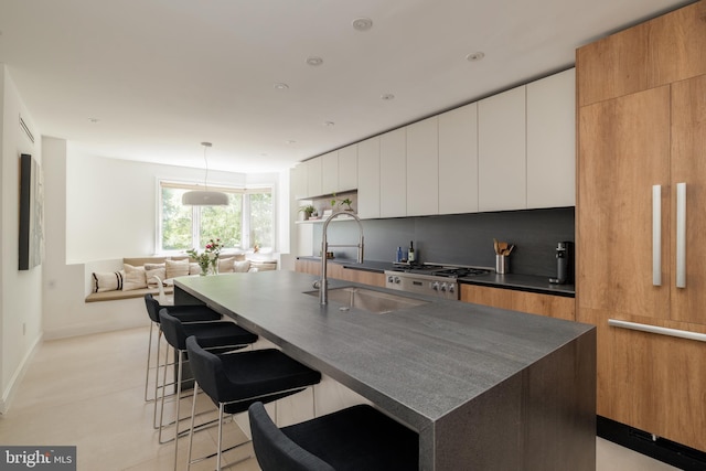 1914 35th St NW, Washington, DC 20007 - kitchen featuring modern cabinets, dark countertops, a breakfast bar, and white cabinets