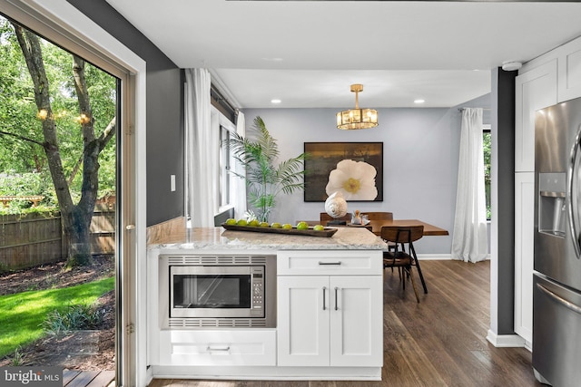 4431 Flintstone Rd, Alexandria, VA 22306 - kitchen with appliances with stainless steel finishes, white cabinets, dark wood-type flooring, light stone countertops, and baseboards
