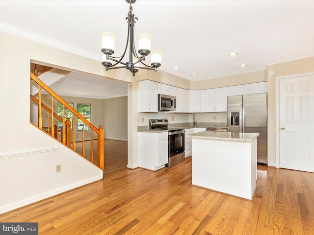 20313 Cedarhurst Way, Germantown, MD 20876 - kitchen featuring appliances with stainless steel finishes, a chandelier, white cabinetry, light wood-style flooring, and crown molding