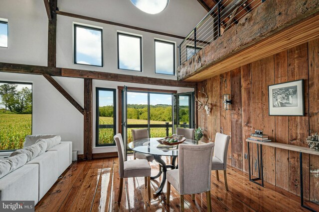 820 Spring Hill Rd, Riegelsville, PA 18077 - dining space with wood walls, hardwood / wood-style flooring, a high ceiling, and baseboards