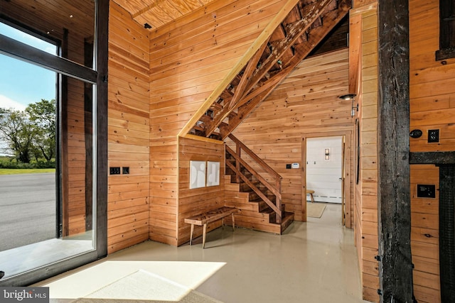 820 Spring Hill Rd, Riegelsville, PA 18077 - entrance foyer with wooden walls, finished concrete floors, a towering ceiling, and baseboard heating