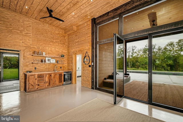 820 Spring Hill Rd, Riegelsville, PA 18077 - doorway with wood ceiling, wine cooler, wooden walls, and bar with sink