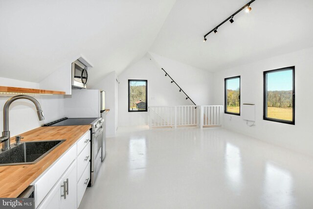 820 Spring Hill Rd, Riegelsville, PA 18077 - kitchen with butcher block countertops, stainless steel appliances, a sink, white cabinetry, and vaulted ceiling