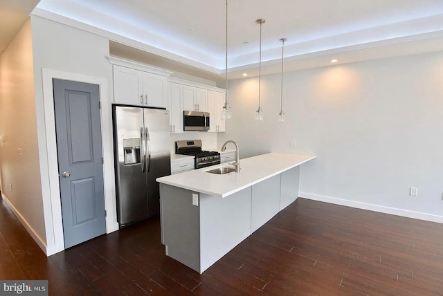 1337 N Franklin St, Philadelphia, PA 19122 - kitchen featuring appliances with stainless steel finishes, a sink, dark wood finished floors, a peninsula, and white cabinets