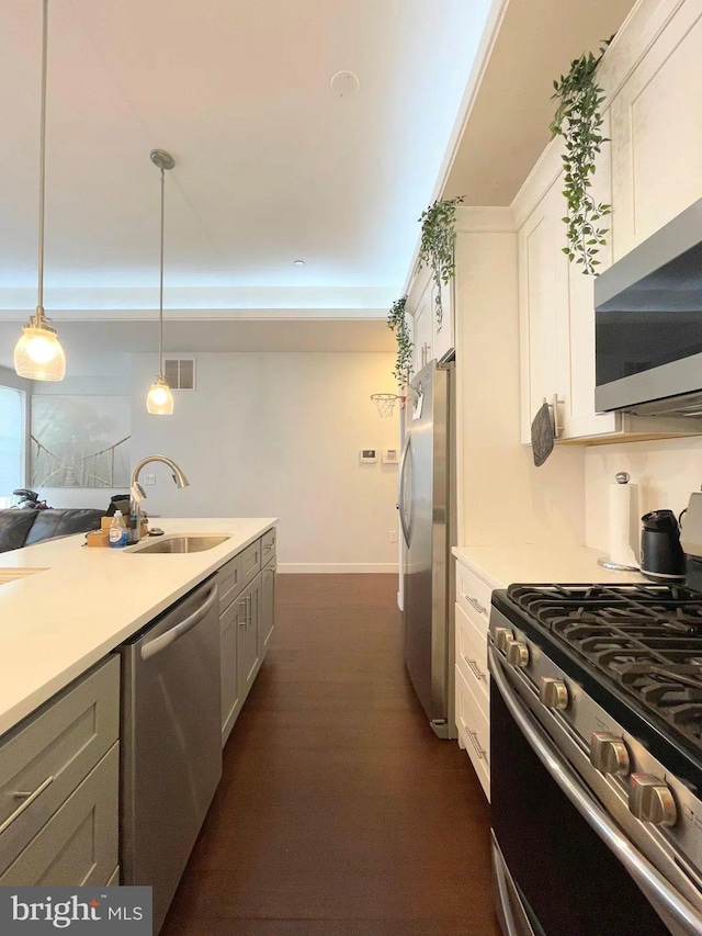 1337 N Franklin St, Philadelphia, PA 19122 - kitchen with stainless steel appliances, a sink, light countertops, decorative light fixtures, and white cabinets
