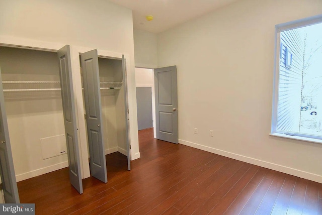 1337 N Franklin St, Philadelphia, PA 19122 - unfurnished bedroom featuring multiple windows, dark wood-type flooring, and baseboards