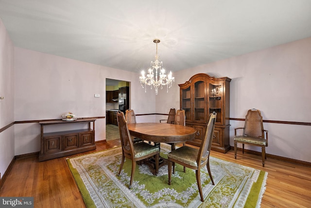 2507 Garth Rd, Wilmington, DE 19810 - dining area featuring a chandelier, wood finished floors, and baseboards