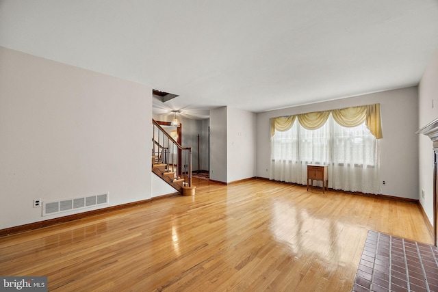 2507 Garth Rd, Wilmington, DE 19810 - unfurnished living room featuring stairway, wood finished floors, a fireplace with flush hearth, and baseboards