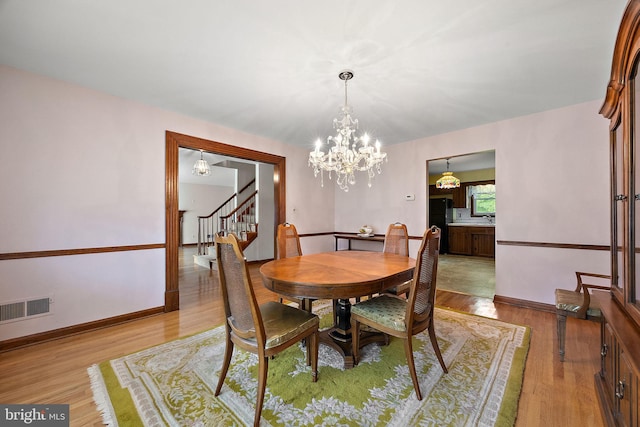 2507 Garth Rd, Wilmington, DE 19810 - dining area featuring stairway, light wood finished floors, a chandelier, and baseboards