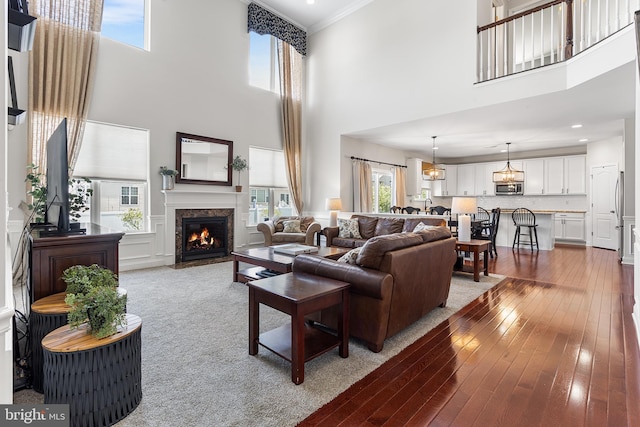 318 Windsor Rd, Mullica Hill, NJ 08062 - living room featuring a towering ceiling, a premium fireplace, plenty of natural light, hardwood / wood-style flooring, and crown molding