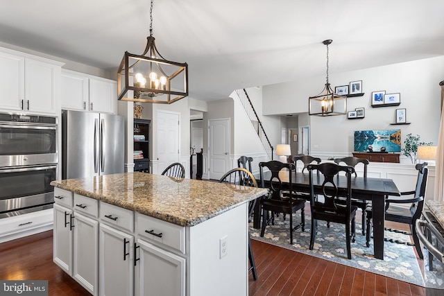 318 Windsor Rd, Mullica Hill, NJ 08062 - kitchen featuring appliances with stainless steel finishes, a chandelier, dark wood-type flooring, a center island, and light stone countertops