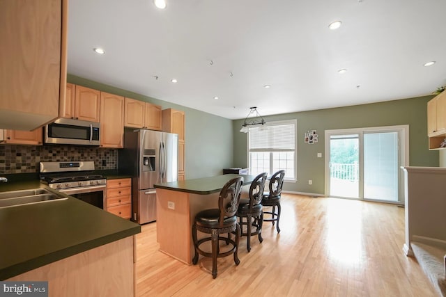 3627 Singleton Ter, Frederick, MD 21704 - kitchen featuring appliances with stainless steel finishes, a kitchen island, dark countertops, tasteful backsplash, and a sink