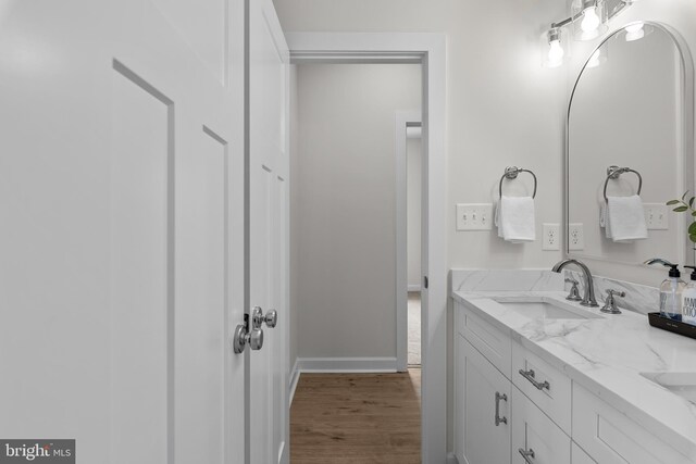 6978 Bray Rd, Hayes, VA 23072 - bathroom featuring double vanity, wood finished floors, and baseboards