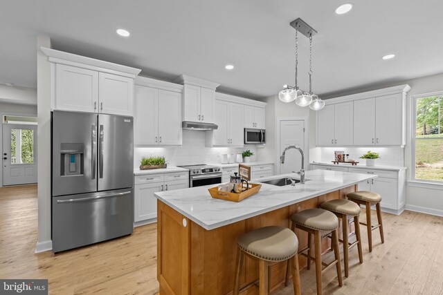 6978 Bray Rd, Hayes, VA 23072 - kitchen featuring appliances with stainless steel finishes, under cabinet range hood, a sink, white cabinets, and recessed lighting