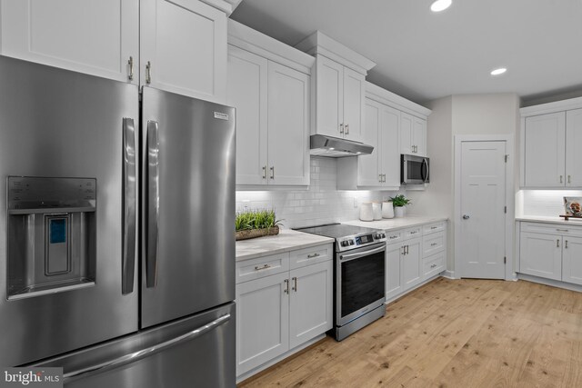 6978 Bray Rd, Hayes, VA 23072 - kitchen with appliances with stainless steel finishes, under cabinet range hood, recessed lighting, decorative backsplash, and light wood-type flooring