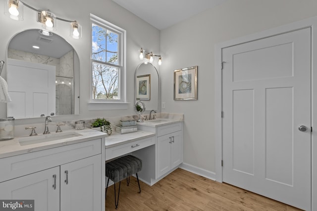 6978 Bray Rd, Hayes, VA 23072 - full bathroom with double vanity, a tile shower, wood finished floors, and baseboards