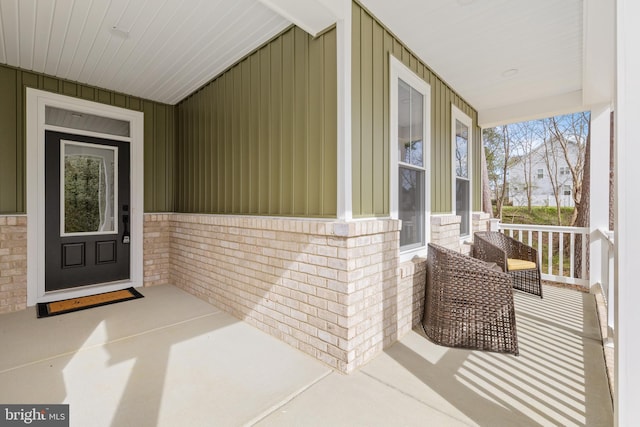 6978 Bray Rd, Hayes, VA 23072 - view of exterior entry with a porch, board and batten siding, and brick siding