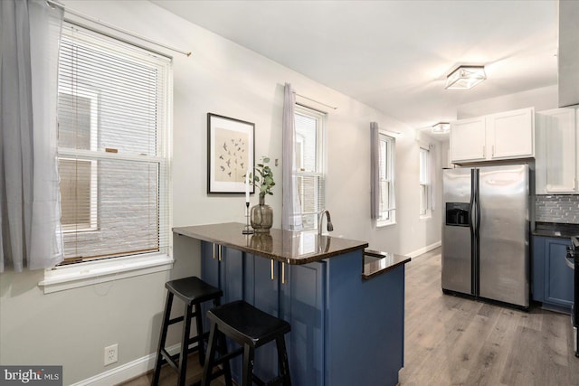 57 E Heath St, Baltimore, MD 21230 - kitchen featuring stainless steel fridge with ice dispenser, dark countertops, a breakfast bar area, baseboards, and white cabinets