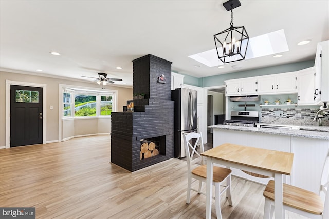5214 Juliet St, Springfield, VA 22151 - kitchen with stainless steel appliances, a skylight, open shelves, white cabinets, and light stone countertops