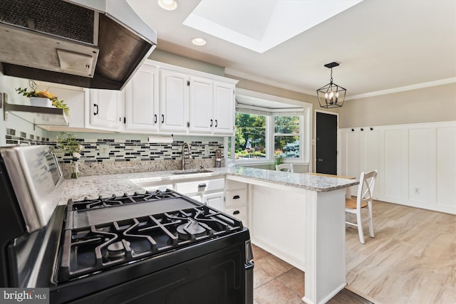 5214 Juliet St, Springfield, VA 22151 - kitchen with extractor fan, black range with gas cooktop, a skylight, white cabinets, and backsplash