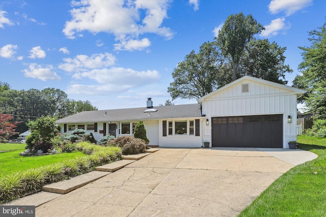 5214 Juliet St, Springfield, VA 22151 - view of front facade with board and batten siding, concrete driveway, an attached garage, and a front yard