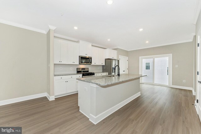 509 Abigail Ave, Waynesboro, PA 17268 - kitchen featuring appliances with stainless steel finishes, crown molding, an island with sink, baseboards, and light wood-style flooring
