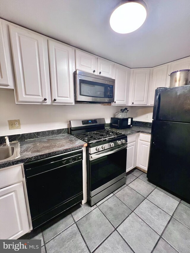 2634 Bowen Rd SE Unit 101, Washington, DC 20020 - kitchen with black appliances, light tile patterned floors, white cabinetry, dark countertops, and a sink