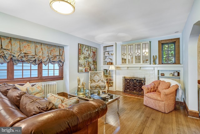 2305 S Inge St S, Arlington, VA 22202 - living room featuring radiator heating unit, wood-type flooring, healthy amount of natural light, and arched walkways