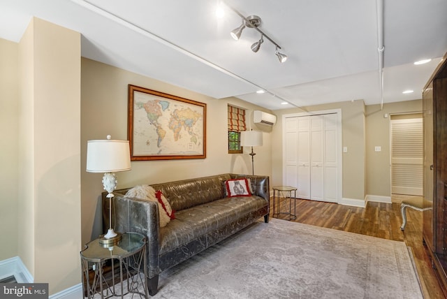 2305 S Inge St S, Arlington, VA 22202 - living area featuring wood finished floors, baseboards, an AC wall unit, recessed lighting, and rail lighting