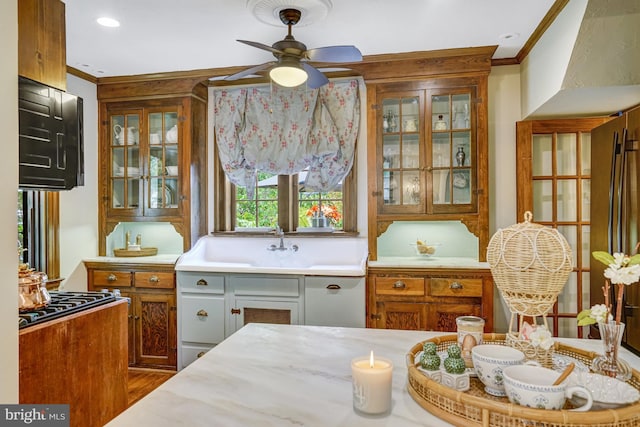 2305 S Inge St S, Arlington, VA 22202 - kitchen featuring ornamental molding, ceiling fan, glass insert cabinets, light countertops, and brown cabinets
