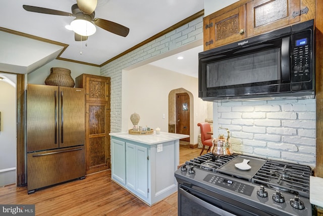 2305 S Inge St S, Arlington, VA 22202 - kitchen featuring refrigerator, black microwave, gas range, arched walkways, and ornamental molding