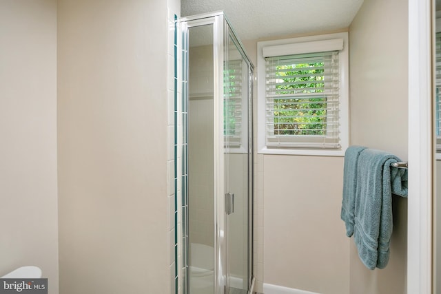 261 E Juniper Ave, Sterling, VA 20164 - bathroom featuring a shower stall, a textured ceiling, and toilet