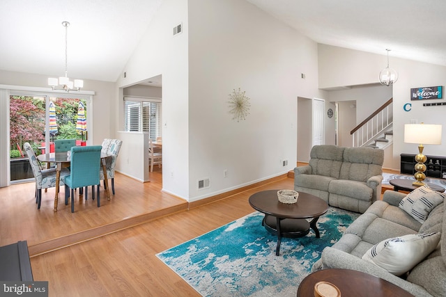 261 E Juniper Ave, Sterling, VA 20164 - living area featuring a chandelier, stairway, high vaulted ceiling, wood finished floors, and baseboards