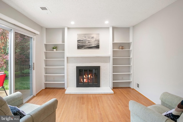 261 E Juniper Ave, Sterling, VA 20164 - living area with wood finished floors, a fireplace, a textured ceiling, and recessed lighting