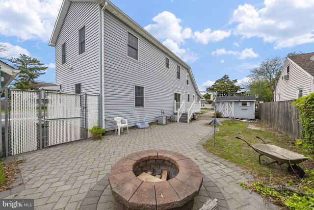 2034 Beach Blvd, Point Pleasant Boro, NJ 08742 - rear view of property featuring a patio area, a fire pit, a fenced backyard, a gate, and central AC