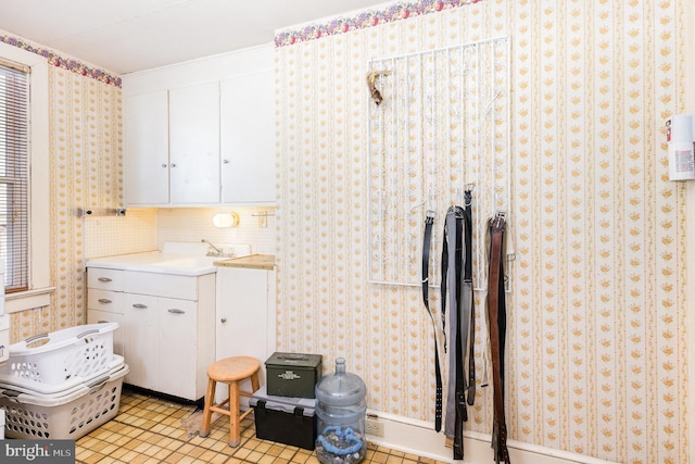 1751 Temple Ave, Lancaster, PA 17603 - kitchen with a sink, white cabinetry, wallpapered walls, and light countertops