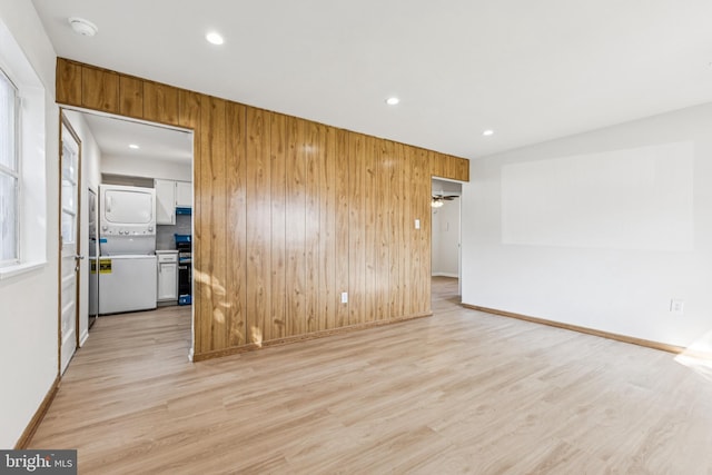 135 Polk Dr, Manassas Park, VA 20111 - spare room with stacked washing machine and dryer, wood walls, light wood-style floors, baseboards, and recessed lighting
