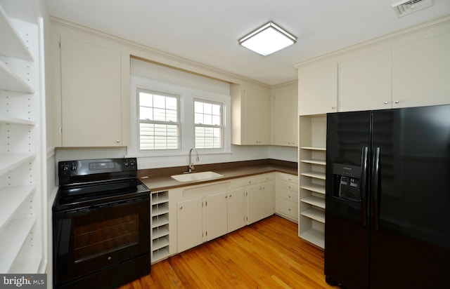 31 W Whitlock Ave, Winchester, VA 22601 - kitchen featuring black appliances, a sink, open shelves, light wood-type flooring, and dark countertops