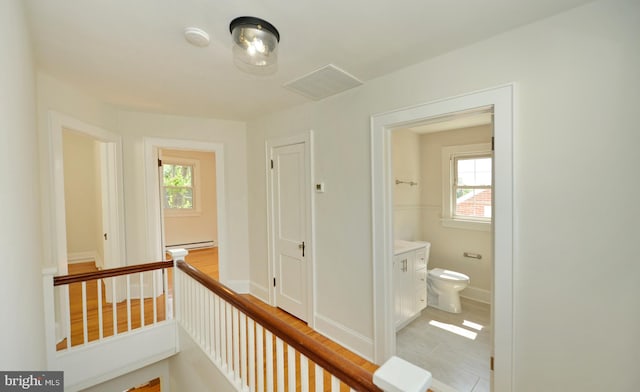 31 W Whitlock Ave, Winchester, VA 22601 - hallway featuring a baseboard heating unit, an upstairs landing, and baseboards