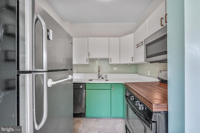 2515 K St NW Unit 205, Washington, DC 20037 - kitchen featuring stainless steel appliances, a sink, decorative backsplash, and white cabinets