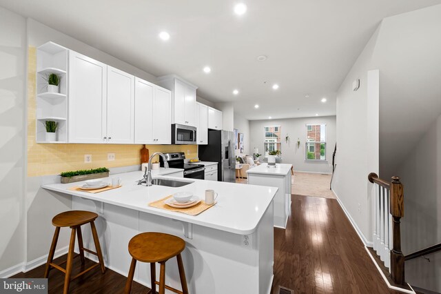 229 S Macon St, Baltimore, MD 21224 - kitchen featuring appliances with stainless steel finishes, open shelves, a kitchen island, a sink, and tasteful backsplash