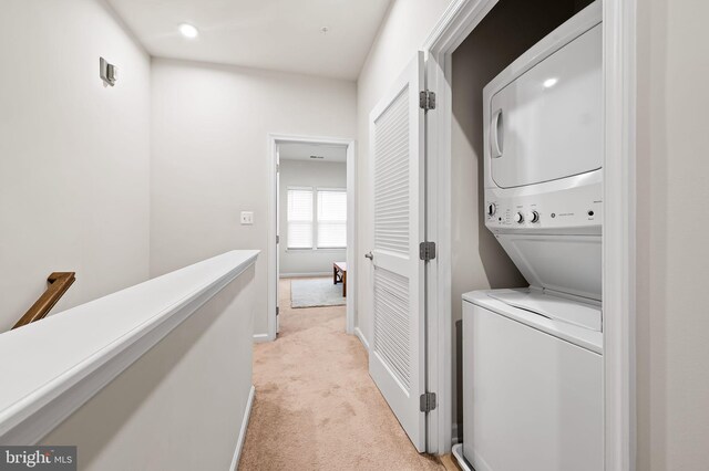 229 S Macon St, Baltimore, MD 21224 - washroom featuring stacked washer / drying machine, light carpet, and baseboards