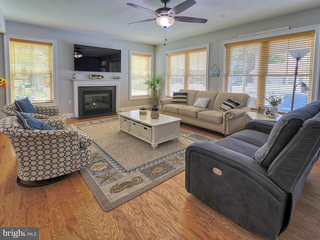 37529 Atlantic Ave Unit 11, Rehoboth Beach, DE 19971 - living room featuring a ceiling fan, a fireplace with flush hearth, wood finished floors, and baseboards