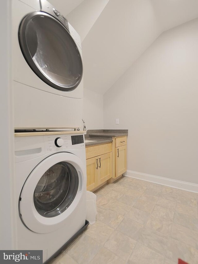 37529 Atlantic Ave Unit 11, Rehoboth Beach, DE 19971 - laundry room with stacked washing machine and dryer, cabinet space, and baseboards