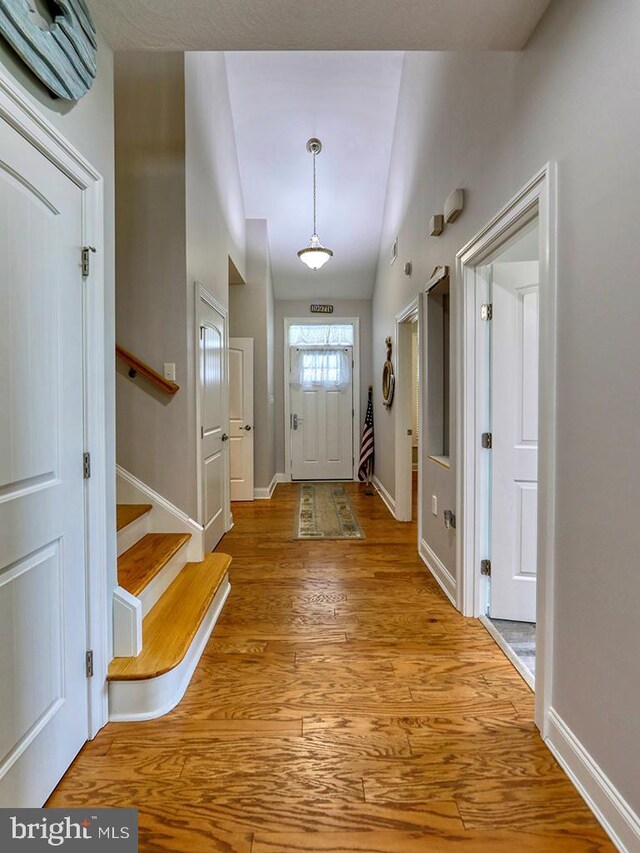 37529 Atlantic Ave Unit 11, Rehoboth Beach, DE 19971 - entryway with wood finished floors, baseboards, stairs, vaulted ceiling, and an AC wall unit